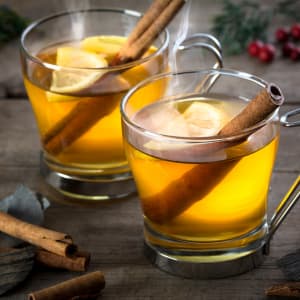 Picture of two glasses of hot apple cider with cinnamon