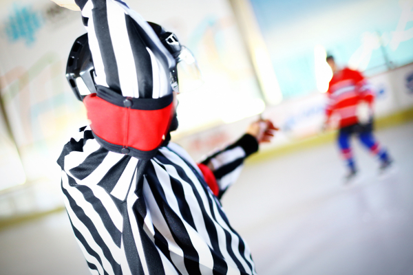 Ice Hockey Referee demonstrating what an embellishment penalty is