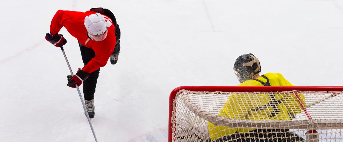 Player taking a shot on a Goalie in front of a net