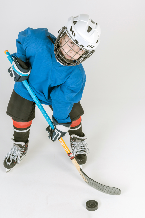 young boy in full hockey equipment to protect himself from injury
