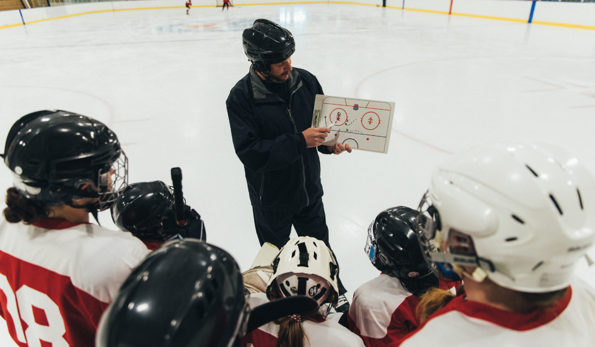 Ice hockey coach showing how to make a pass