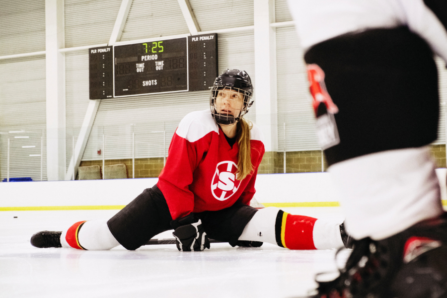 female hockey player demonstrating stretching and flexibility to prevent injury