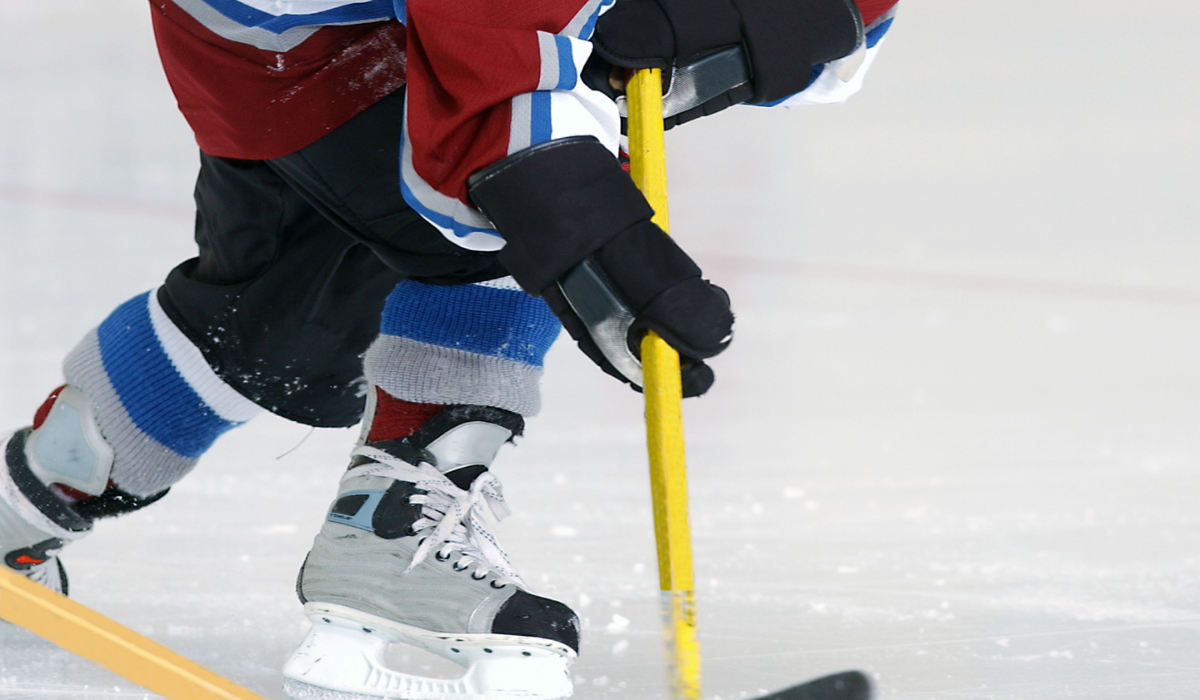 youth ice hockey player making a pass