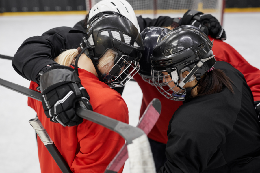 four female ice hockey players in circle 