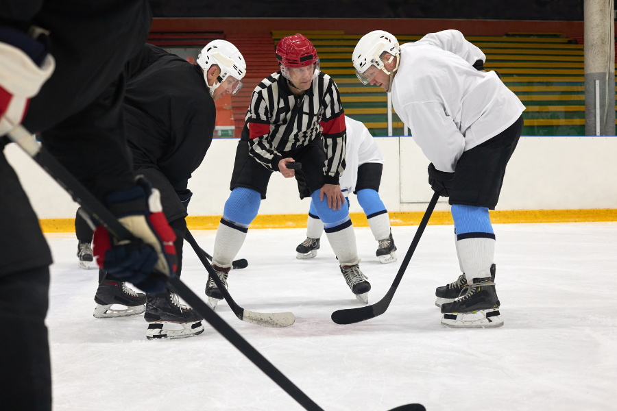 offensive line at a face off with referre about to drop the puck