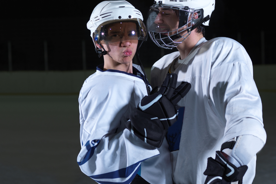 two ice hockey players who play defense smiling