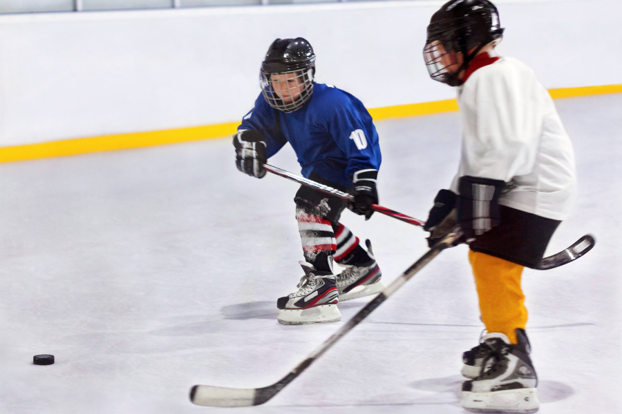 Two children at Ice Hockey practicing plays
